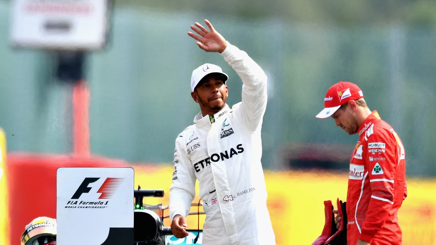 Lewis Hamilton saluda al público con Vettel cabizbajo al fondo Lewis Hamilton saluda al público con Vettel cabizbajo al fondo