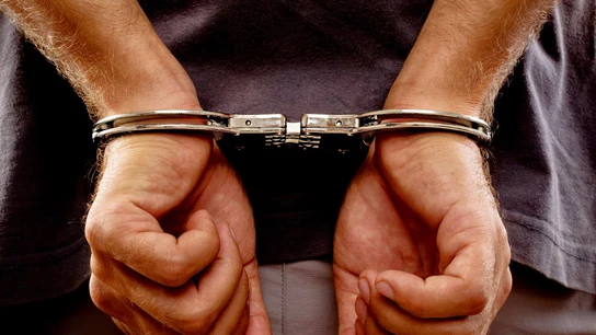 Un hombre detenido con esposas Un hombre detenido con esposas