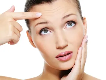 Una mujer se toca las arrugas Una mujer se toca las arrugas