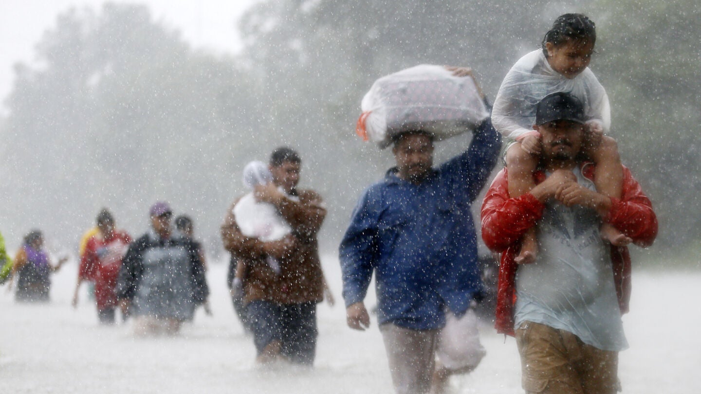 Los residentes caminan por zonas inundadas que deja la tormenta tropical Harvey en Beaumont Place, Houston