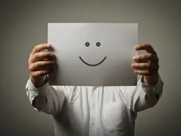 Un hombre sujeta una cara sonriente Un hombre sujeta una cara sonriente