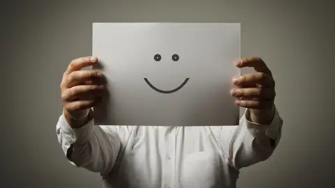 Un hombre sujeta una cara sonriente Un hombre sujeta una cara sonriente