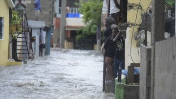 Personas observan una calle inundada en República Dominicana