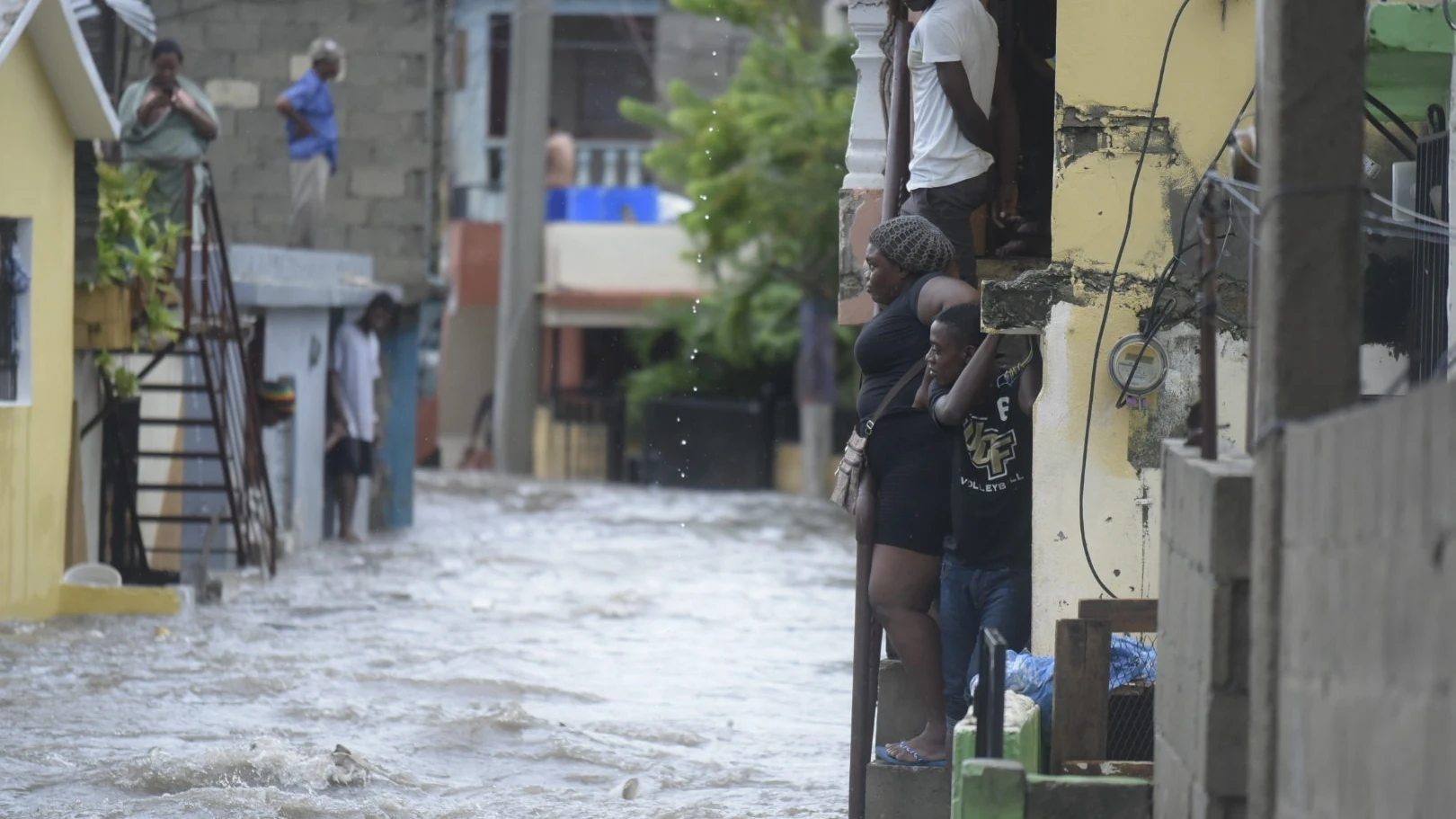 Personas observan una calle inundada en República Dominicana