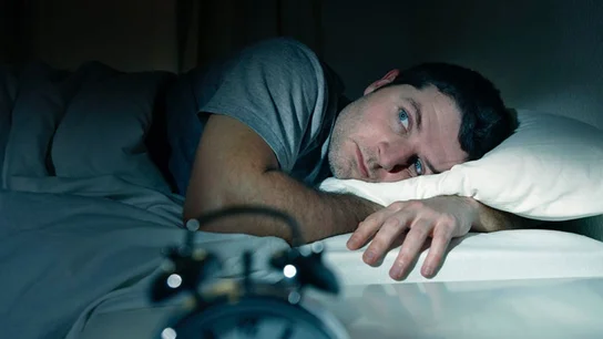 Imagen de archivo de un hombre tratando de dormir. Imagen de archivo de un hombre tratando de dormir.