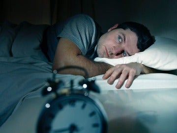 Imagen de archivo de un hombre tratando de dormir.