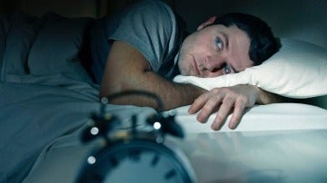 Imagen de archivo de un hombre tratando de dormir.