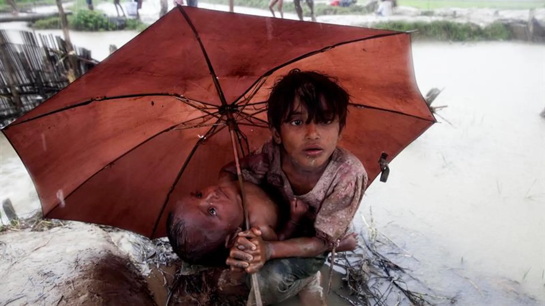 Dos niños rohinyás se refugian de la lluvia