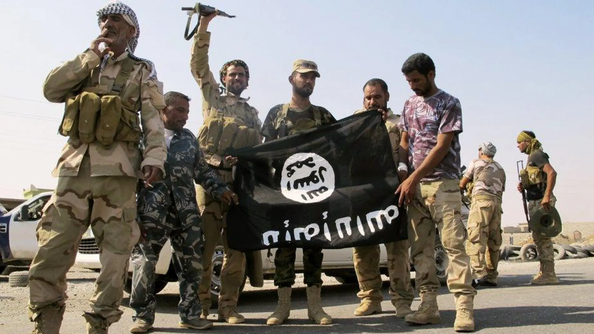 Unos soldados de Daesh exhiben su bandera