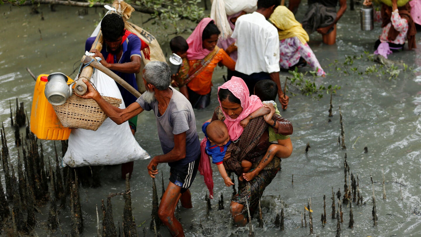 Refugiados rohingya caminan a trav&eacute;s del agua despu&eacute;s de cruzar la frontera en barco a trav&eacute;s del r&iacute;o Naf en Teknaf, Bangladesh