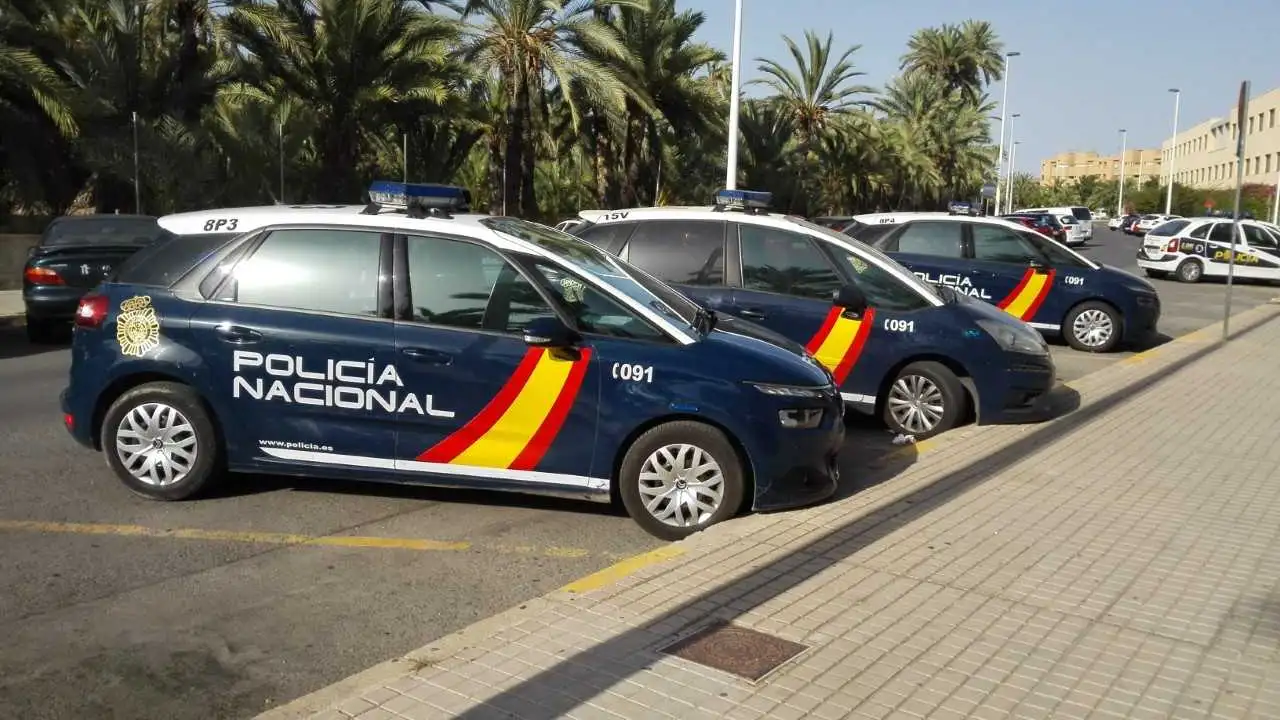 Coches de la Policía Nacional estacionados junto a la Comisaría de Elche.