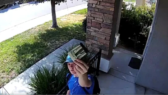 El joven muestra a la cámara de seguridad la cartera encontrada El joven muestra a la cámara de seguridad la cartera encontrada