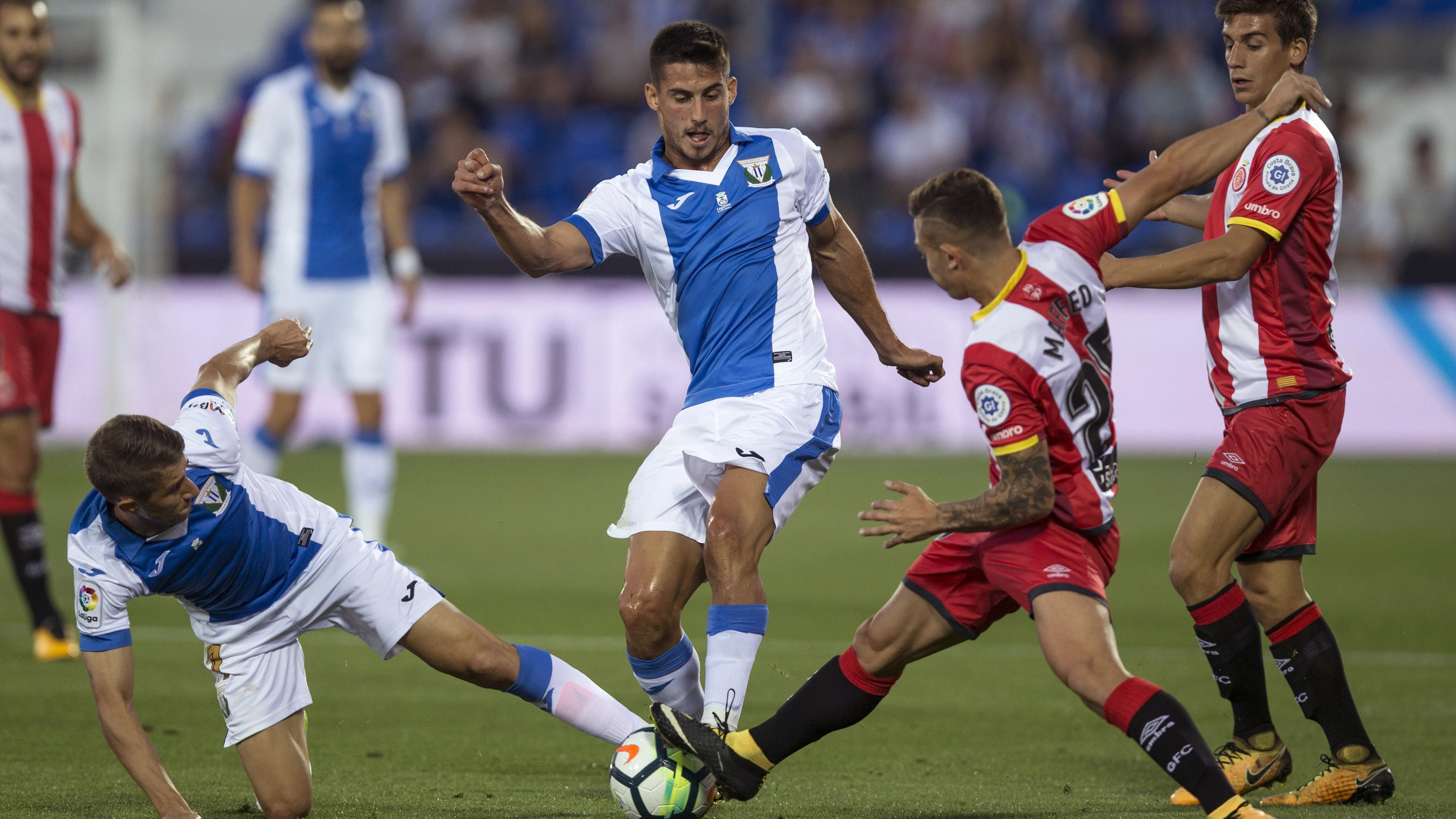 Szymanowski y Pires disputan el balón durante el Leganés - Girona