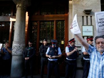 Agentes de la Guardia Civil y de los Mossos d'Esquadra, en la puerta de la consellería de Economía de la Generalitat Agentes de la Guardia Civil y de los Mossos d'Esquadra, en la puerta de la consellería de Economía de la Generalitat