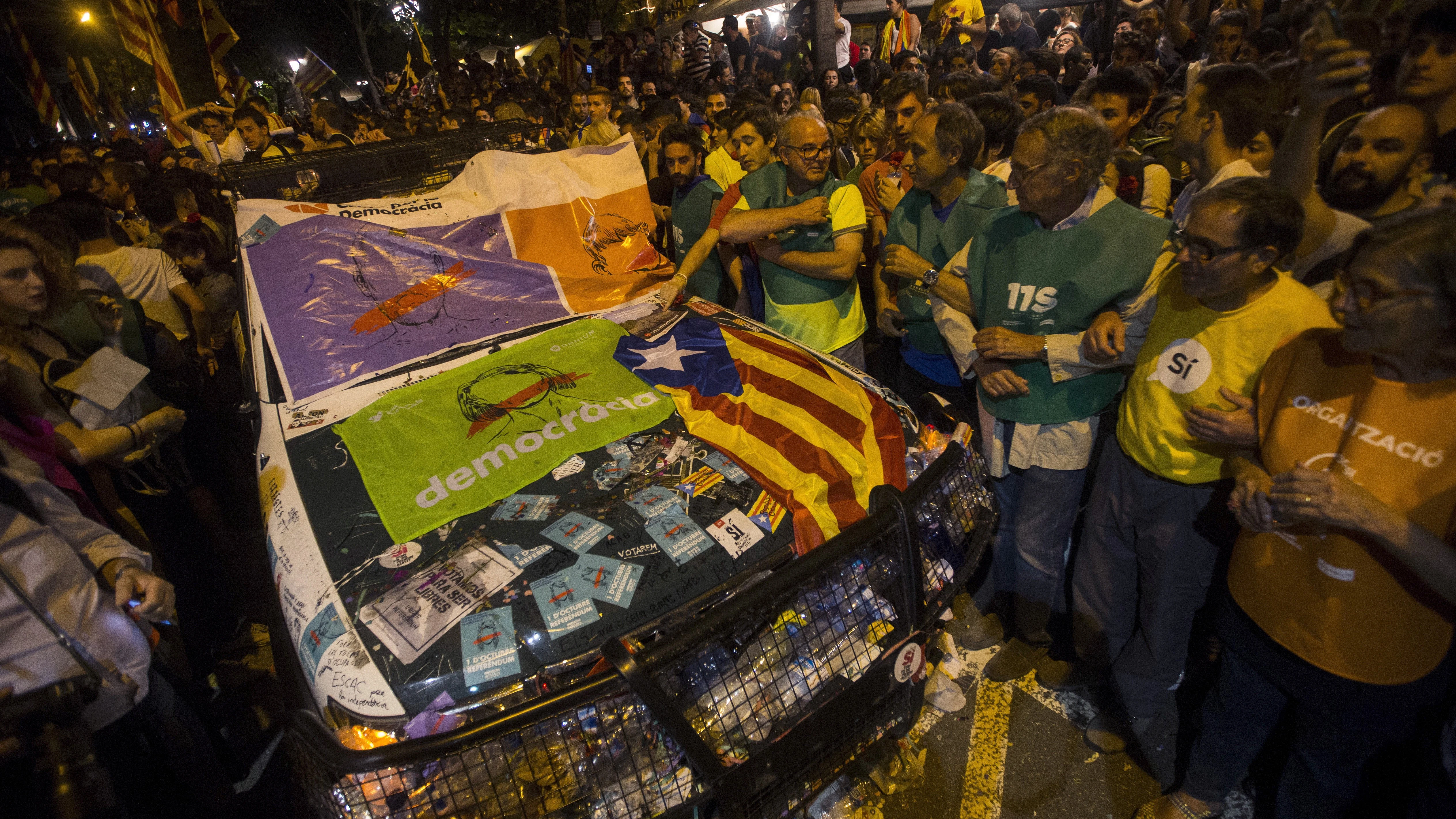 Un coche de la Guardia Civil destrozada frente a la Consellería de Economía