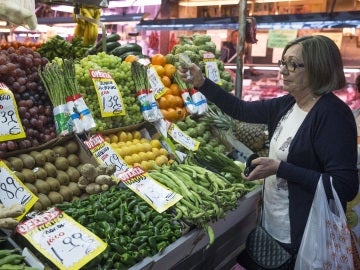En la imagen, una mujer hace su compra en una frutería del mercado Maravilla en Madrid. En la imagen, una mujer hace su compra en una frutería del mercado Maravilla en Madrid.