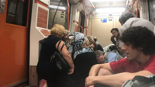 Los pasajeros se agachan dentro del vagón de metro Los pasajeros se agachan dentro del vagón de metro