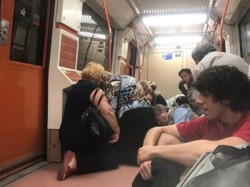 Los pasajeros se agachan dentro del vagón de metro Los pasajeros se agachan dentro del vagón de metro