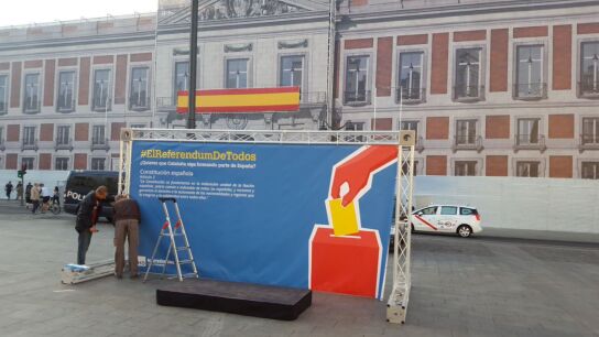 Dos operarios montan la urna del refer&eacute;ndum de Hazte O&iacute;r