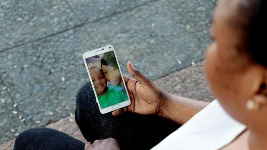Oumo viendo imágenes de su hijo en el móvil Oumo viendo imágenes de su hijo en el móvil