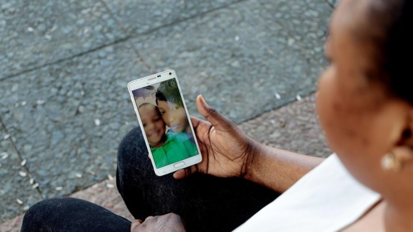 Oumo viendo im&aacute;genes de su hijo en el m&oacute;vil