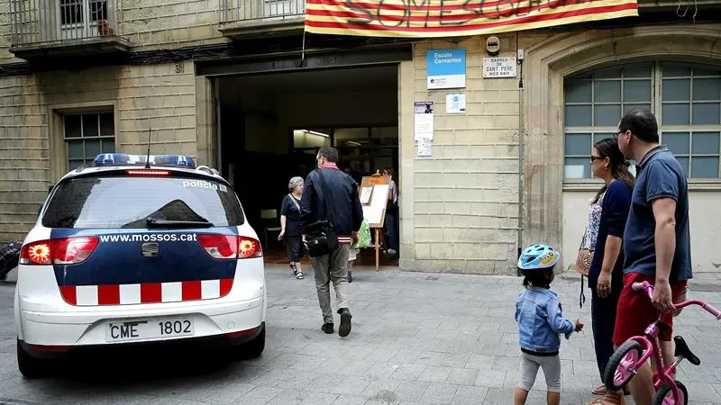 n vehiculo de los Mossos d'Esquadra a la entrada del colegio público Cervantes que permanece abierto 