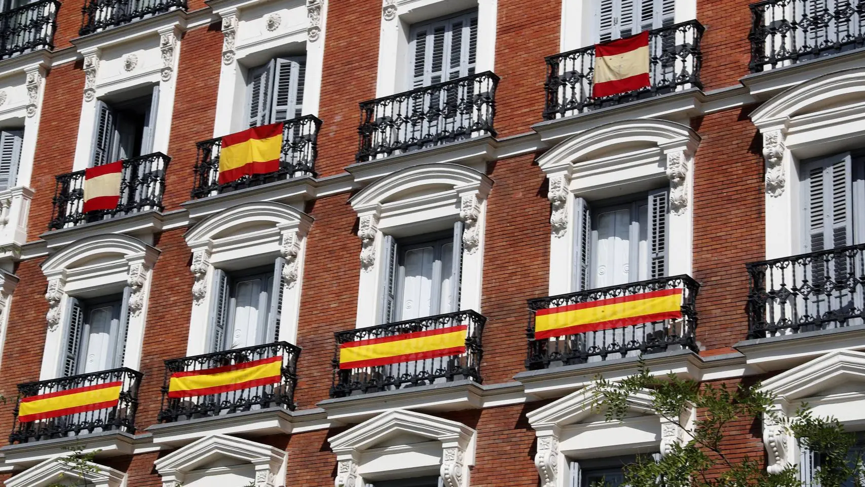 Imagen de archivo de varias banderas españolas colgando de varios balcones en Madrid