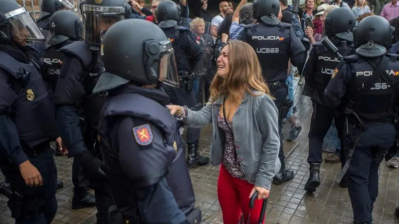 Una joven llora durante la operación de los agentes antidisturbios de la Policía Nacional