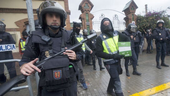 Agentes antidisturbios de la Polic&iacute;a Nacional retiran material