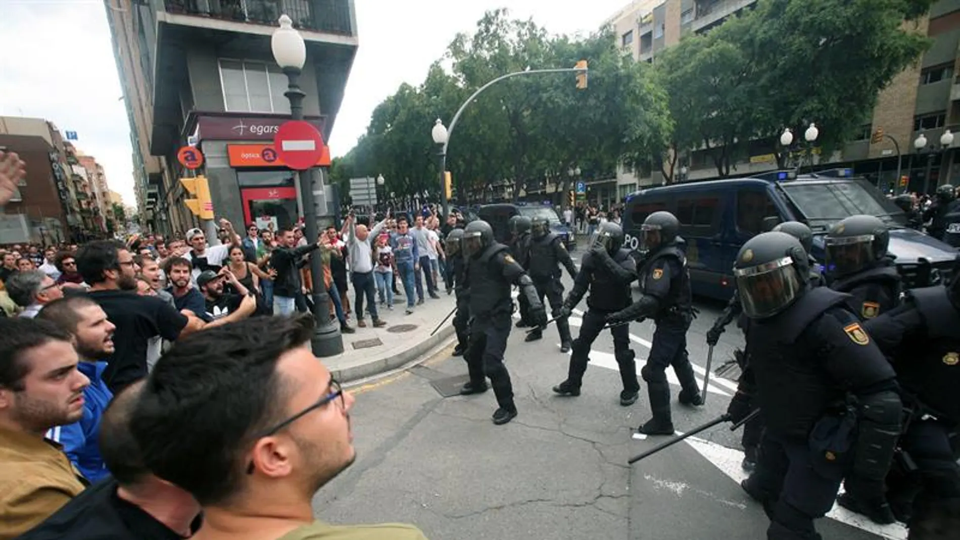 Agentes de la policía nacional forman un cordón policial en el exterior del IES Tarragona