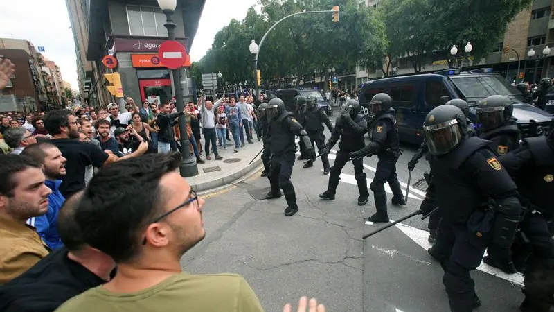 Agentes de la policía nacional forman un cordón policial en el exterior del IES Tarragona