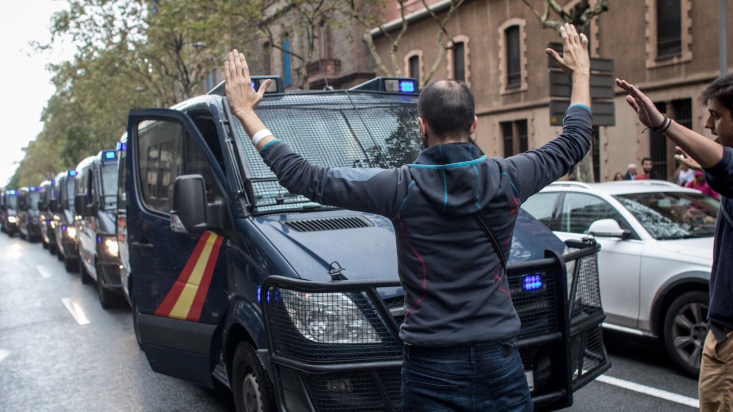 Varios ciudadanos se paran delante de los veh&iacute;culos de la Guardia Civil con los brazos en alto