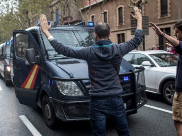Varios ciudadanos se paran delante de los vehículos de la Guardia Civil con los brazos en alto Varios ciudadanos se paran delante de los vehículos de la Guardia Civil con los brazos en alto