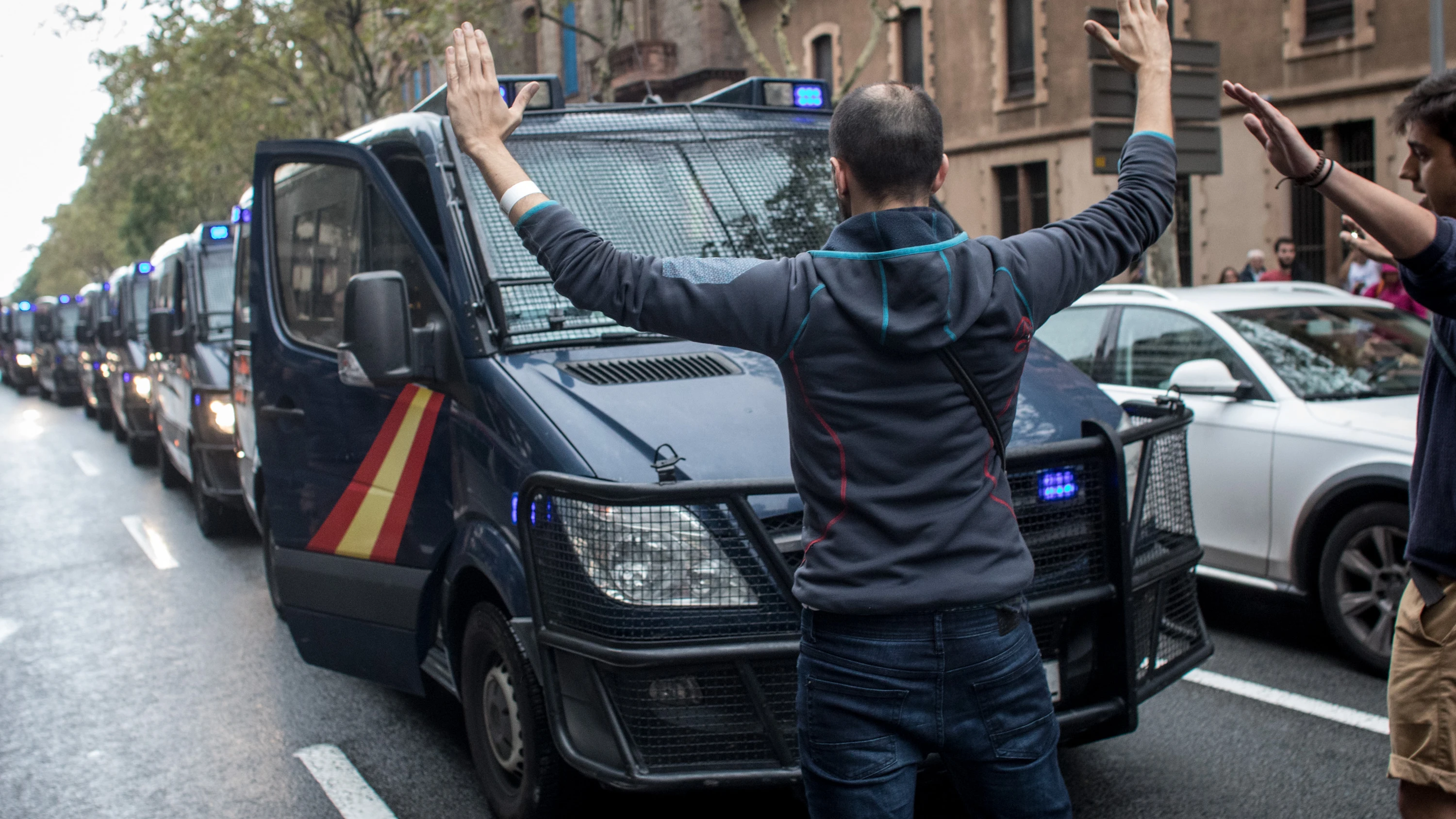 Varios ciudadanos se paran delante de los vehículos de la Guardia Civil con los brazos en alto Varios ciudadanos se paran delante de los vehículos de la Guardia Civil con los brazos en alto