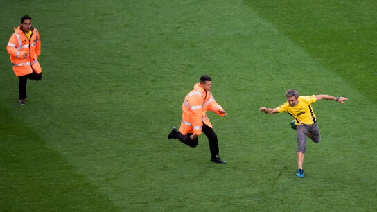 Un aficionado sortea el placaje de un miembro de seguridad en el partido del Bar&ccedil;a a puerta cerrada