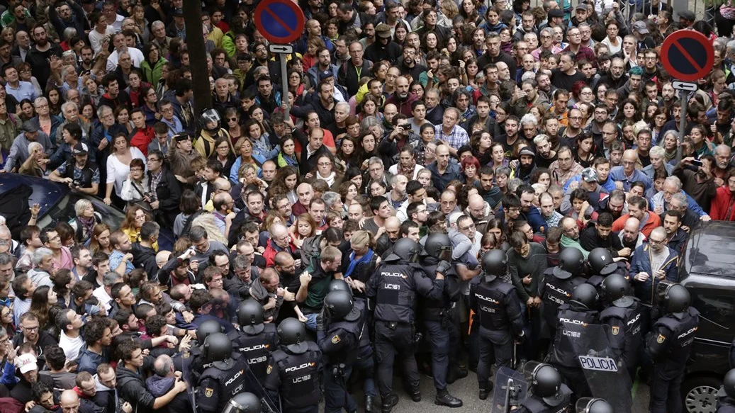 Antidisturbios de la Policía Nacional forman un cordón de seguridad en los alrededores del colegio Ramón Llull de Barcelona