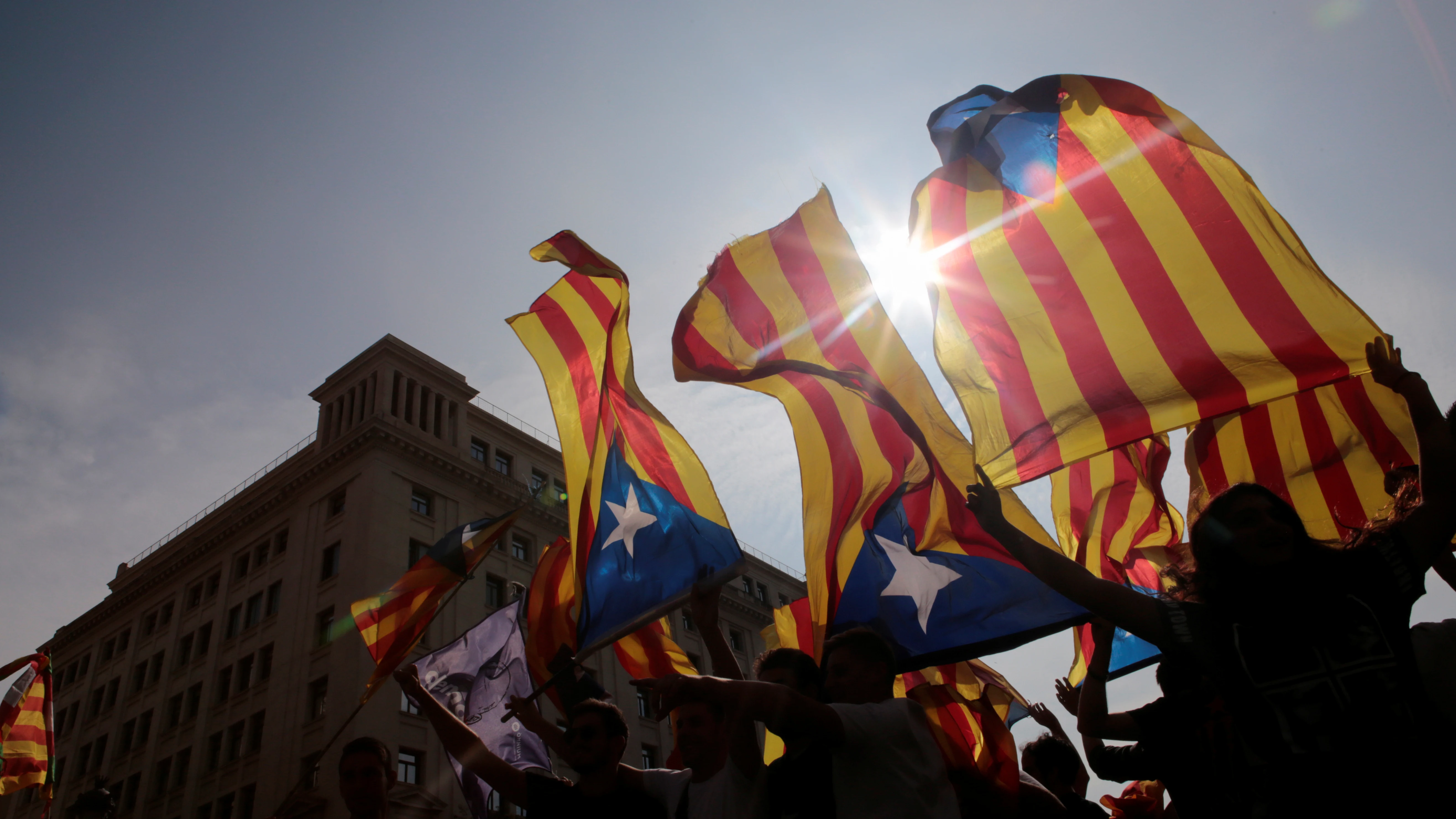 Manifestantes sostienen banderas esteladas durante la huelga del 3-O