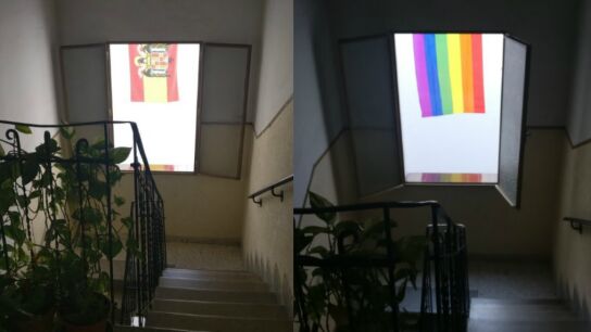Una joven tapa una bandera franquista con otra LGTBI