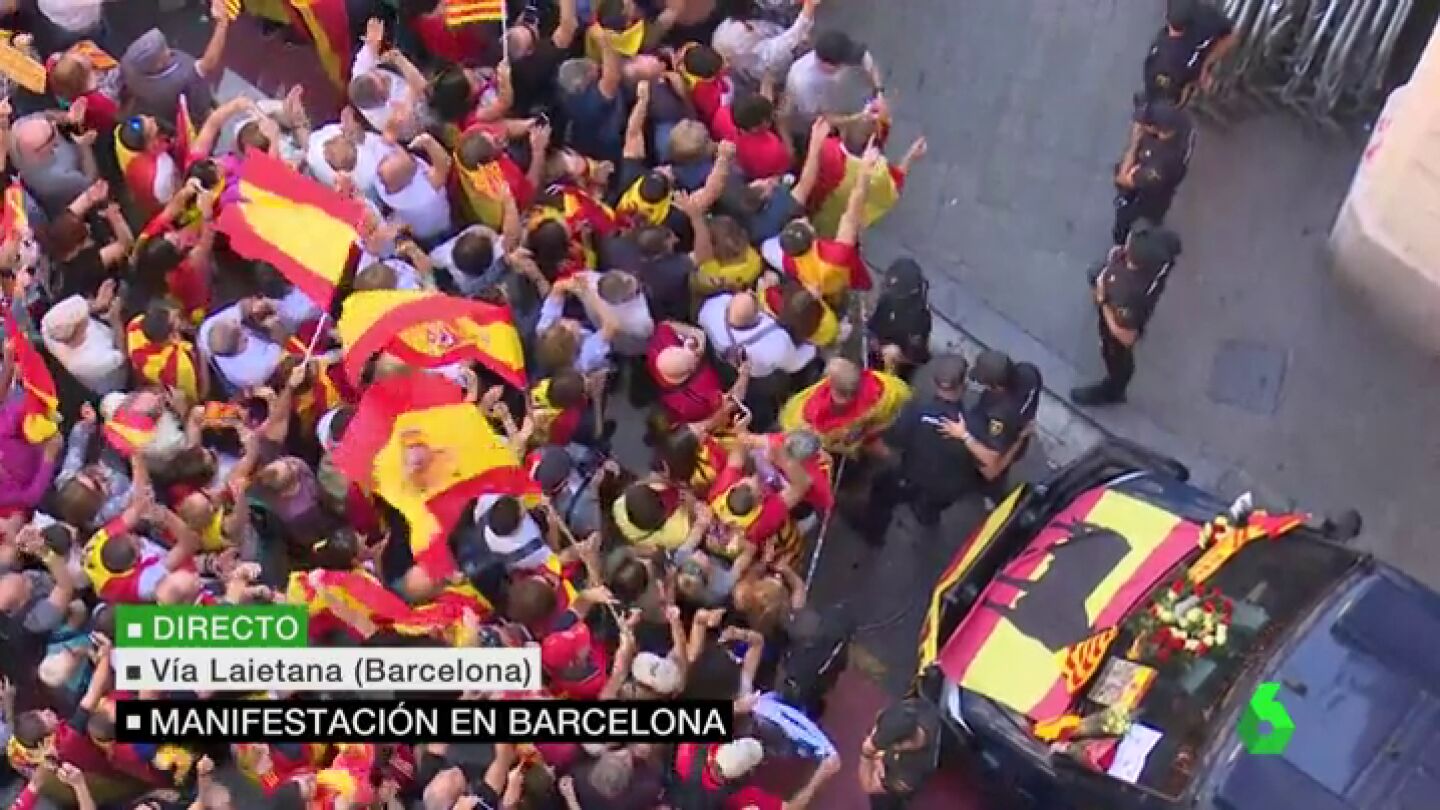 Un grupo de manifestantes entrega flores y banderas de Espa&ntilde;a a los agentes de la Polic&iacute;a Nacional 