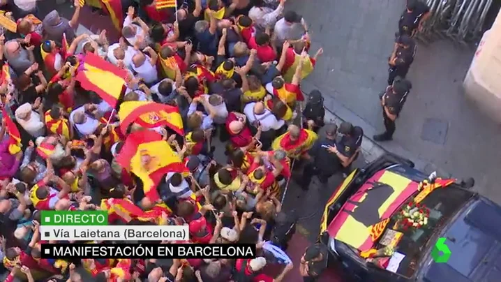 Un grupo de manifestantes entrega flores y banderas de España a los agentes de la Policía Nacional 