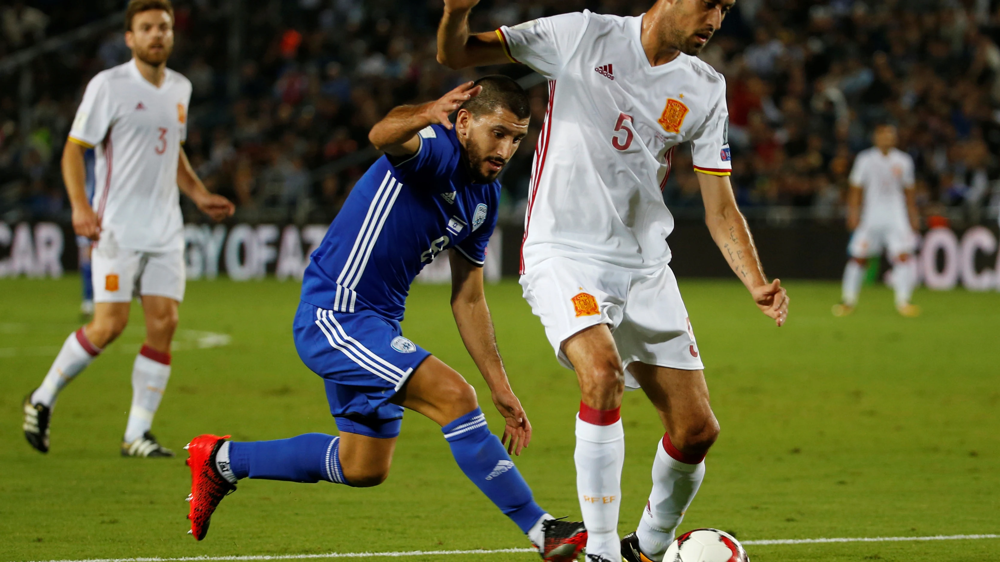 Busquets protege un bal&oacute;n ante la marca de un jugador de Israel