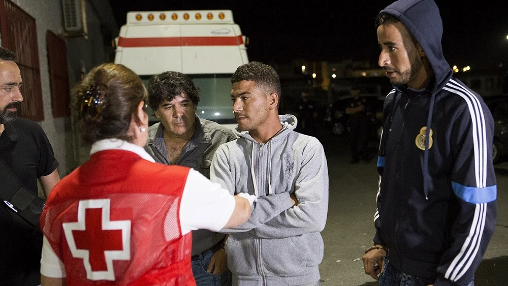 Miembros de la Cruz Roja atienden a un grupo de inmigrantes que viajaba a bordo de una de las pateras rescatadas