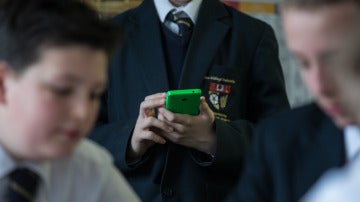 Un alumno con un móvil en el colegio