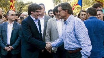 El presidente de la Generalitat, Carles Puigdemont, saluda a Artur Mas