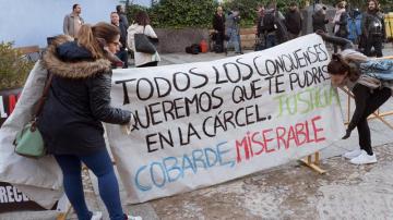 Amigos de las víctimas, Laura y Marina, colocanco una pancarta en la entrada de los juzgados a la llegada de Sergio Morate