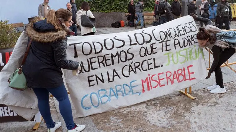 Amigos de las víctimas, Laura y Marina, colocanco una pancarta en la entrada de los juzgados a la llegada de Sergio Morate