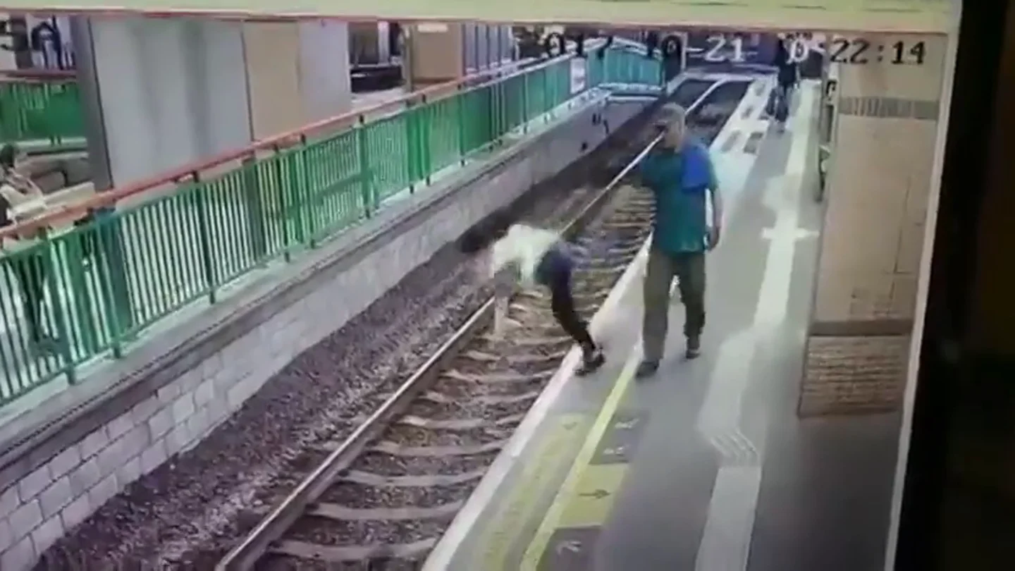 Un hombre empuja a una mujer a las vías del tren y sigue caminando sin inmutarse Un hombre empuja a una mujer a las vías del tren y sigue caminando sin inmutarse
