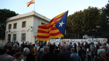 Personas sostienen banderas catalanas frente al consulado español en Perpiñán 