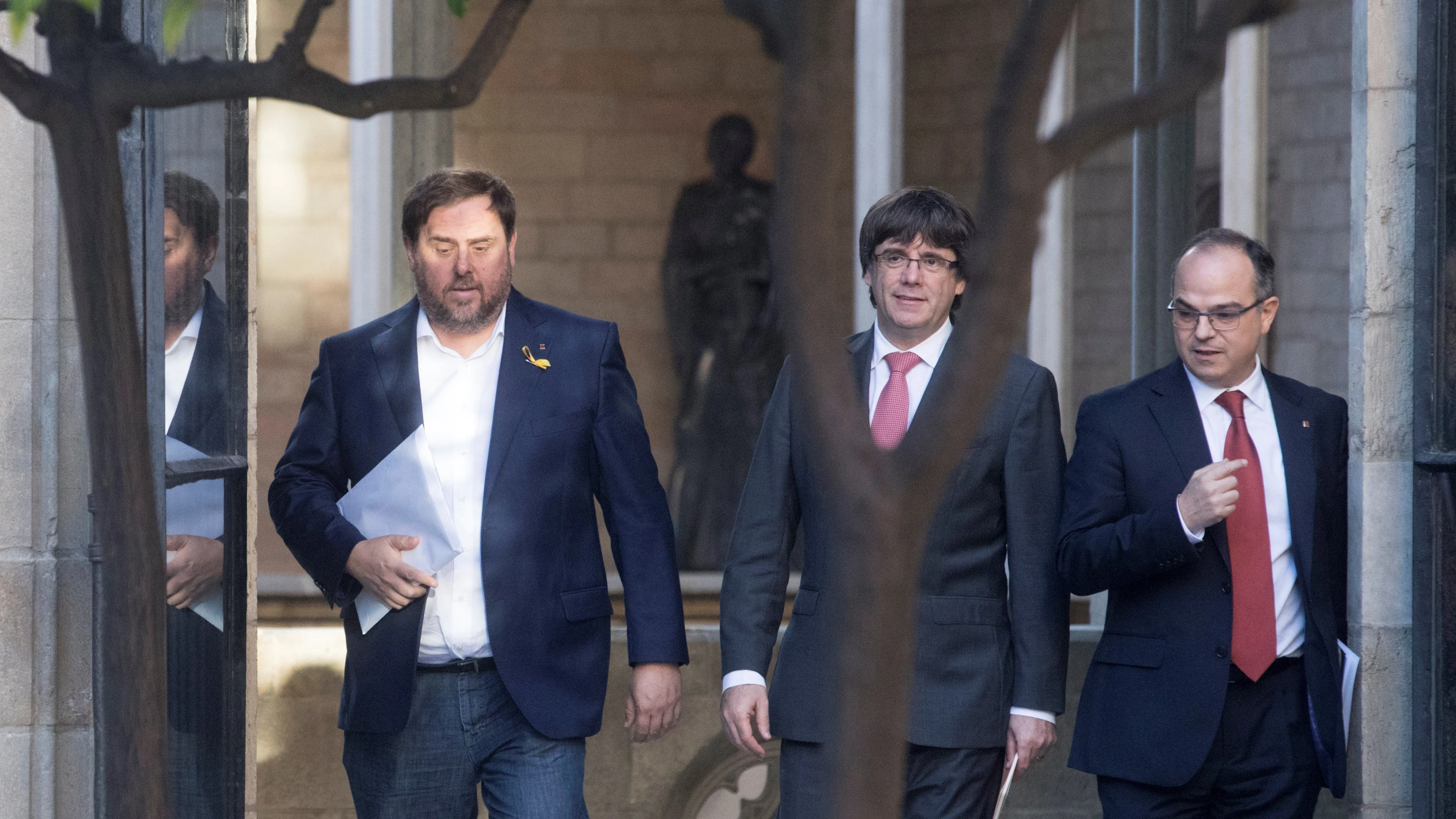 Carles Puigdemont, president de la Generalitat, entre el vicepresident, Oriol Junqueras, y el portavoz del Govern, Jordi Turull