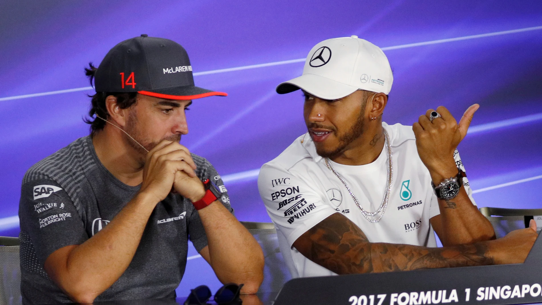 Fernando Alonso y Lews Hamilton dialogan durante el GP de Singapur